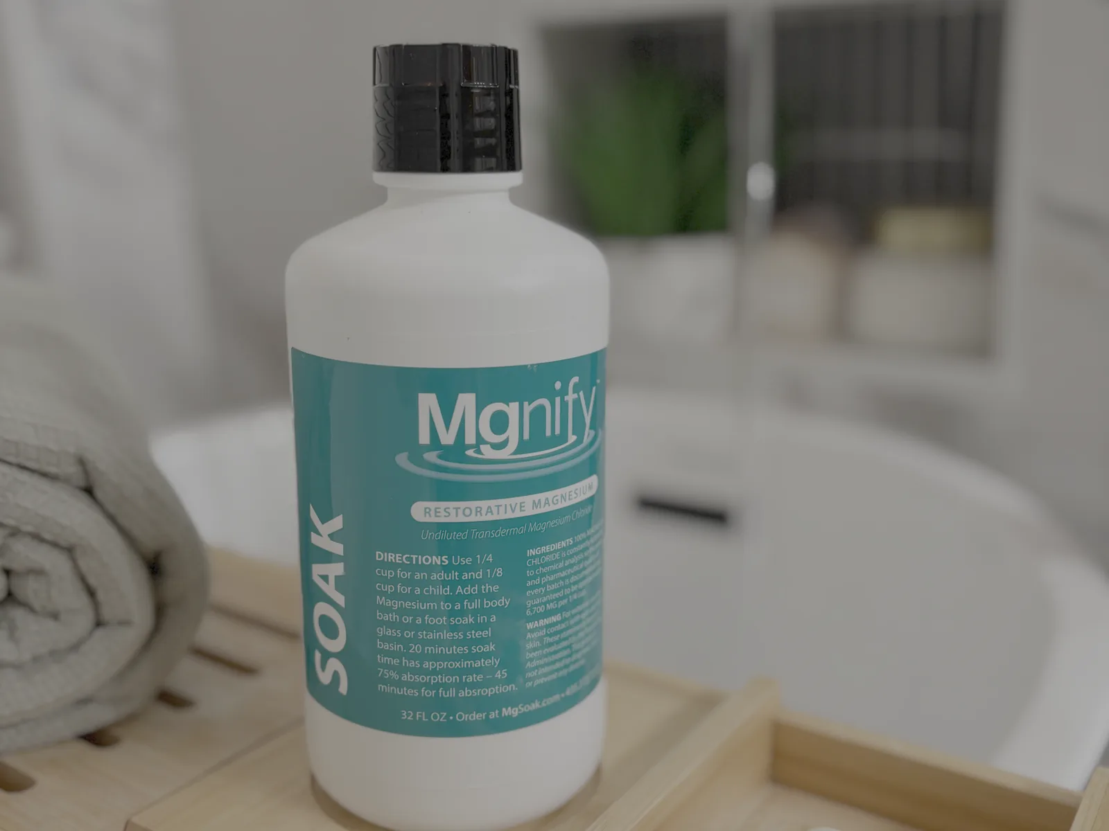 A bottle of Mgnify 32oz magnesium chloride soak on a bath caddy beside the tub